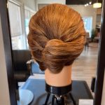 Classic French twist hairstyle on mannequin head created by apprentice stylist Chloe at Rejuvenation Spa.