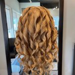 Long, loose curls styled on brunette hair in preparation for an elegant updo by apprentice Chloe at Rejuvenation Spa