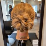 Back view of textured braided bun updo styled by apprentice Chloe at Rejuvenation Spa.