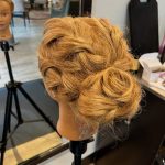 Textured braided bun hairstyle on mannequin created by apprentice Chloe at Rejuvenation Spa.