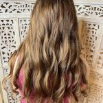 Back view of long, wavy, medium brown hair after an all-over color and curling style.