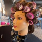 Velcro roller set on a mannequin head to prep for voluminous curls