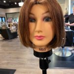 Mannequin with brunette bob haircut styled in a smooth blowout.