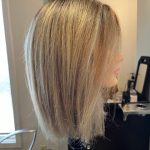 Long blonde mannequin head with a fresh haircut, styled with a sleek and smooth blowout.