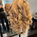 Mannequin styled with prepped curls ready to be pinned into an updo.