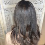 Close-up of brunette guest after a seamless new growth color application, back view.