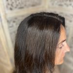 Close-up of brunette guest after a seamless new growth color application, side view.