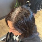 Close-up of brunette guest before a seamless new growth color application.
