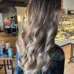 Long brunette hair styled in soft, flowing waves after a blowout using Aveda's new Abundant Blowout Volumizing Spray.