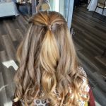 Chloe creating an elegant updo style for a bridal party flower girl during her cosmetology apprenticeship at Rejuvenation Spa.