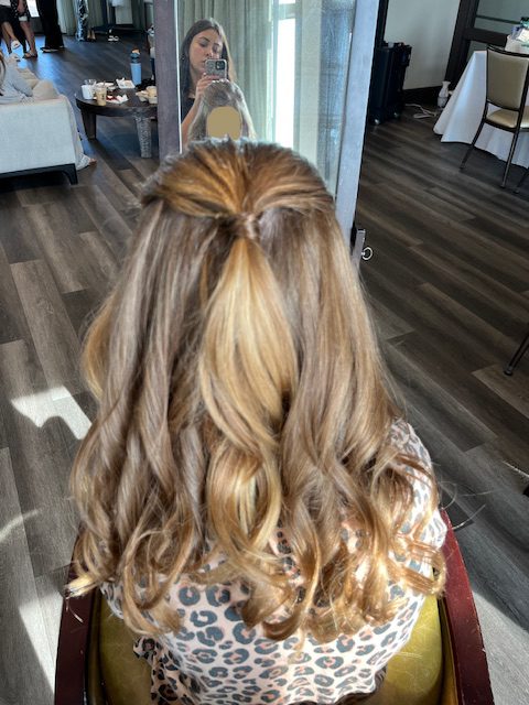 Chloe creating an elegant updo style for a bridal party flower girl during her cosmetology apprenticeship at Rejuvenation Spa.