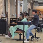Close-up of clean hair sectioning and a blunt cut being performed on the nape of a model’s neck during a hair workshop.